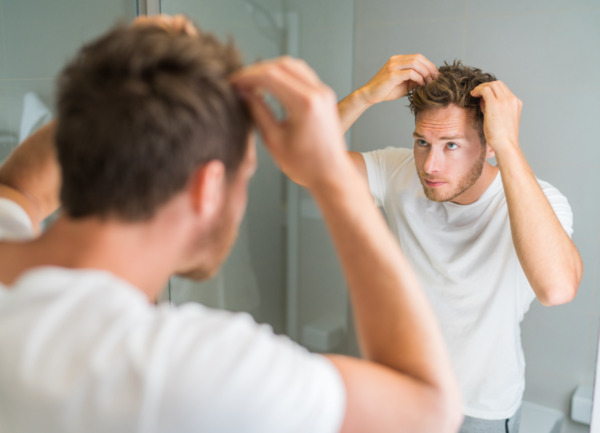 Un homme contrôle la progression de sa guérison après une greffe de cheveux