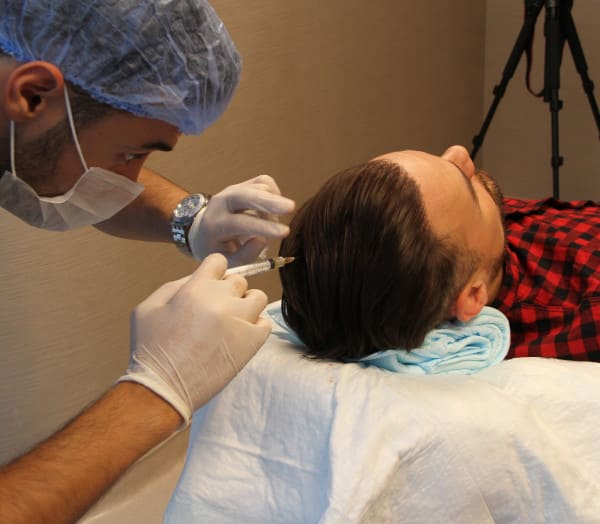 Un patient reçoit une injection de plasma riche en plaquettes ou traitement PRP à la clinique Elithair