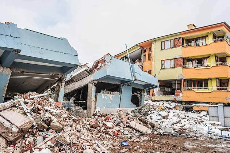 Un bâtiment détruit entouré de débris après un tremblement de terre