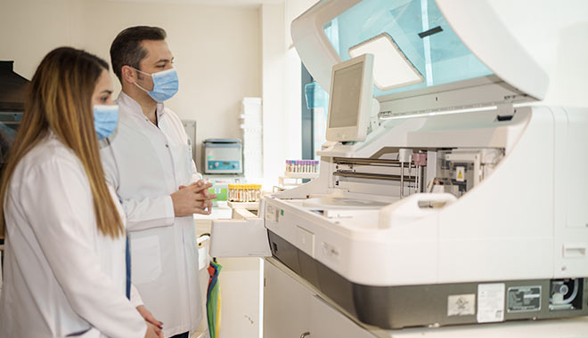 L'image montre le Dr Balwi et un assistant en train d'analyser les résultats d'un patient.