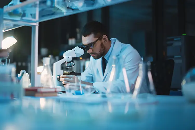 Un scientifique dans son laboratoire observant au microscope pour une recherche d'analyse