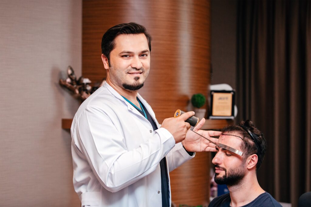 Dr Balwi zeichnet die Haarlinie bei einem Patienten ein