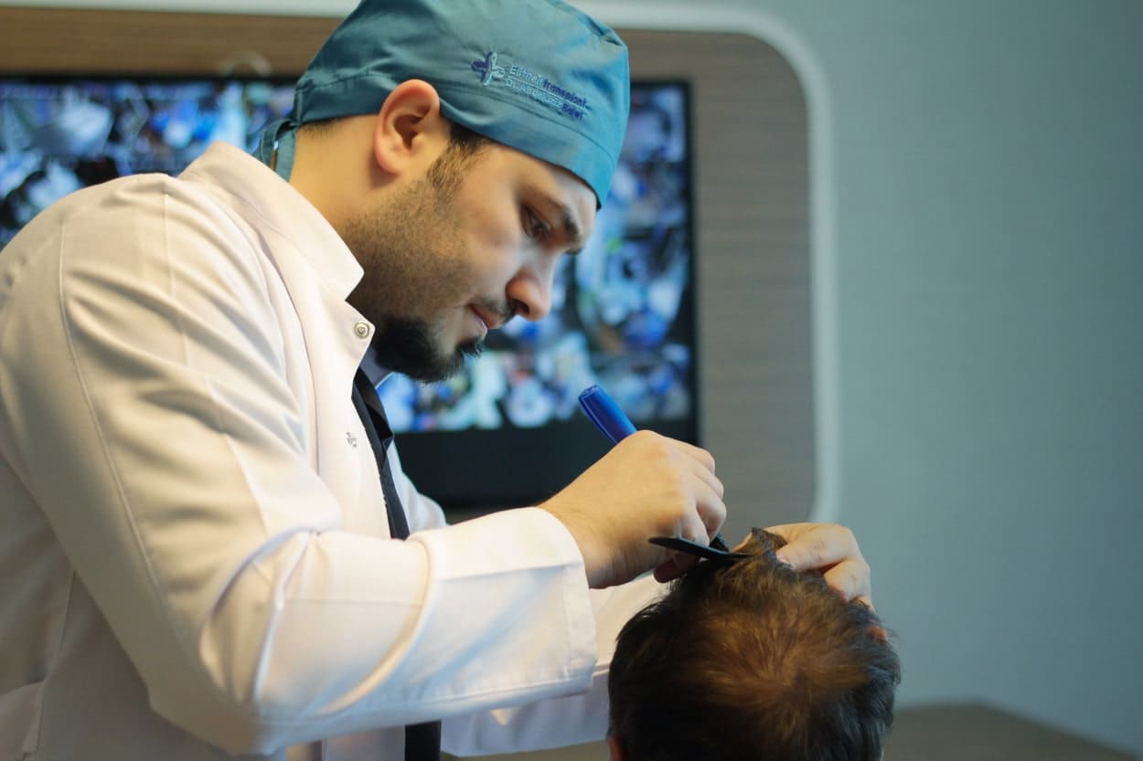 Dr Balwi untersucht die Haare eines Mannes