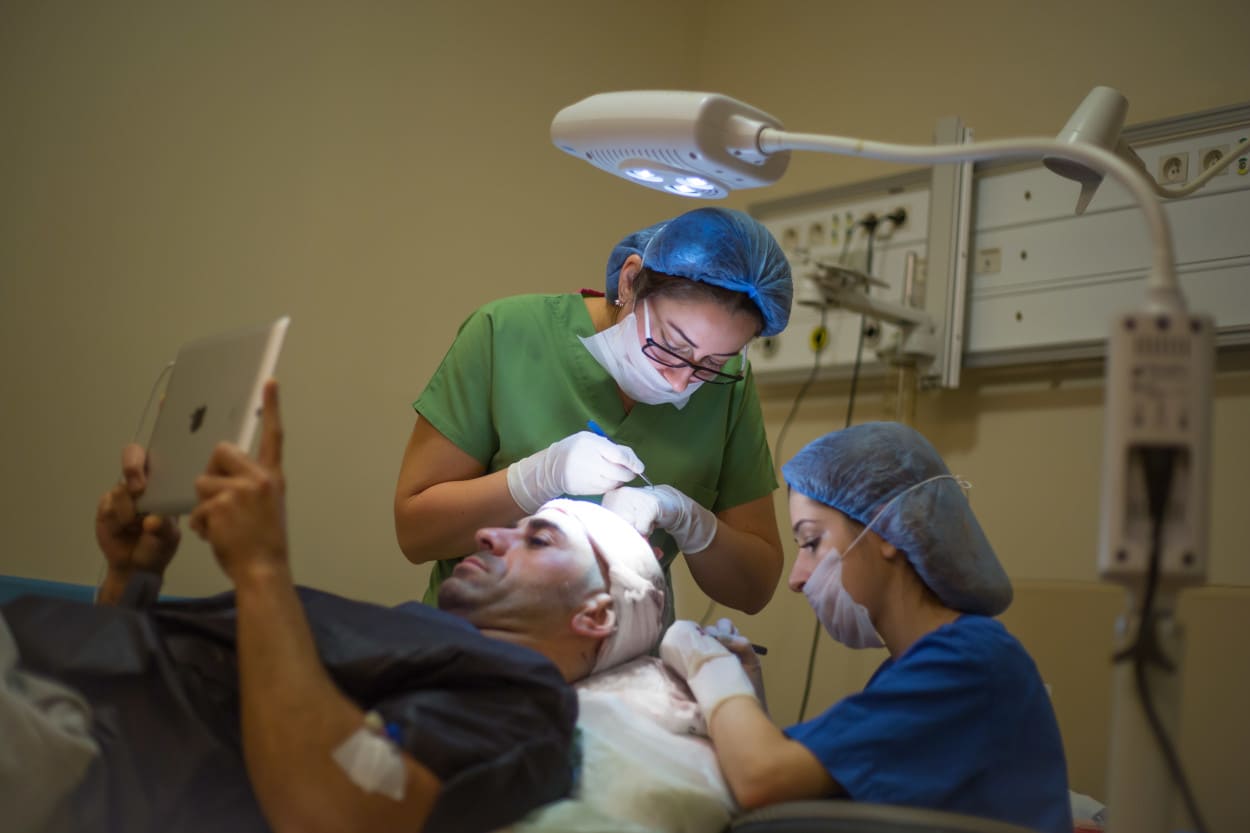 Ärzte führen eine Haartransplantation bei einem Mann durch