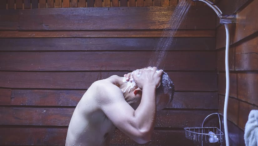 mann wascht haare unter der dusche
