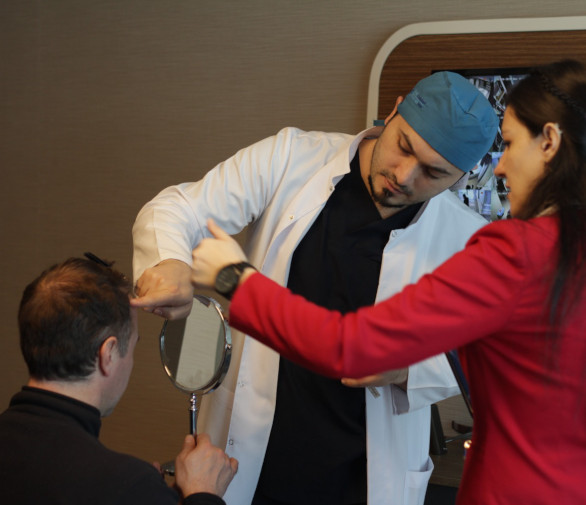 Dr. Balwi analysiert die Haare des Patienten vor der Behandlung