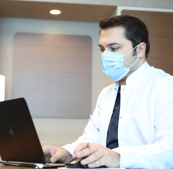 Hair transplant surgeon Dr Balwi working on his laptop