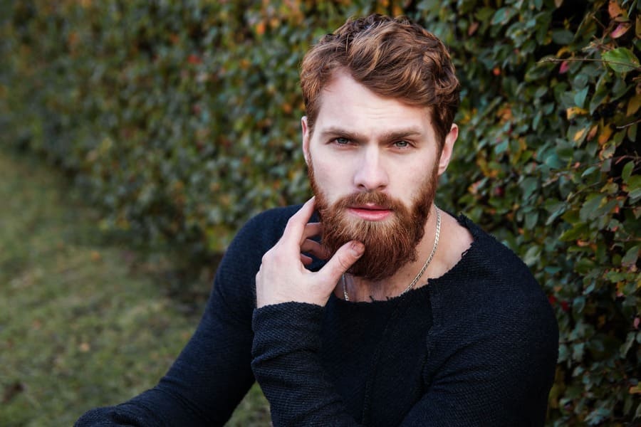 Mann mit vollem Haarwachstum schaut in die Kamera.
