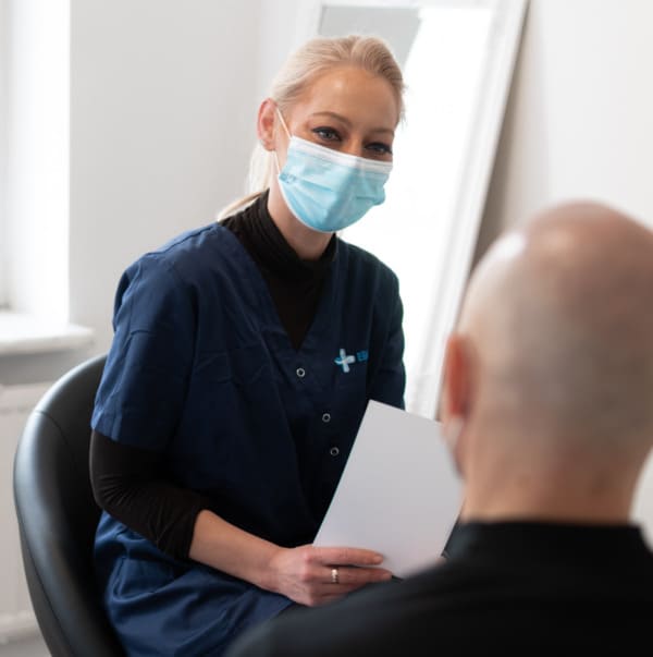 Ein Mitglied des Elithair Teams aus Düsseldorf mit einem Patienten