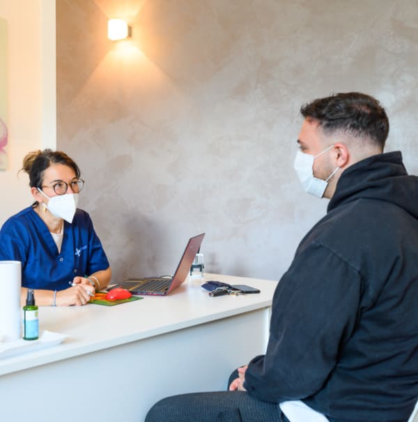 Beratung eines Teammitglieds mit einem Patienten bei Elithair in München
