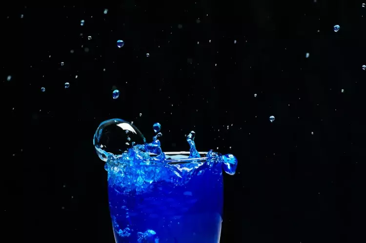 Blauer Energydrink in Glas mit Zucker als schlechten Einfluss für Haarausfall
