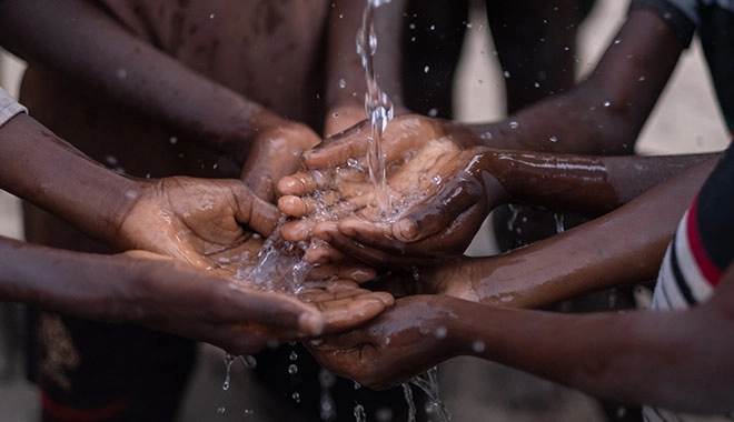 Bild von afrikanischen Kindern, die Wasser auf ihre Hände auftragen