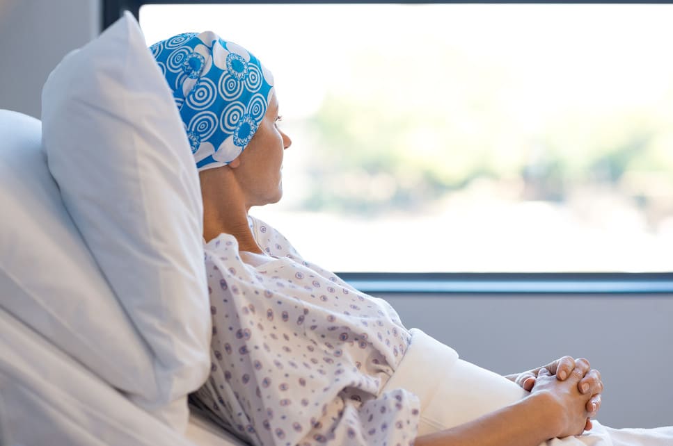 Frau mit Kopftuch liegt im Krankenbett nach Haartransplantation