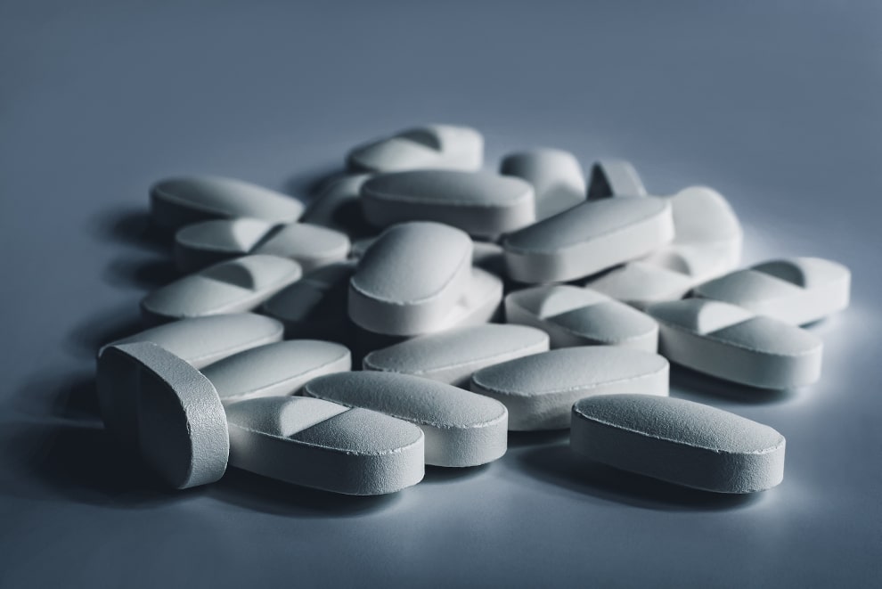 Nahaufnahme verschiedener weißer Tabletten auf einem weißen Hintergrund