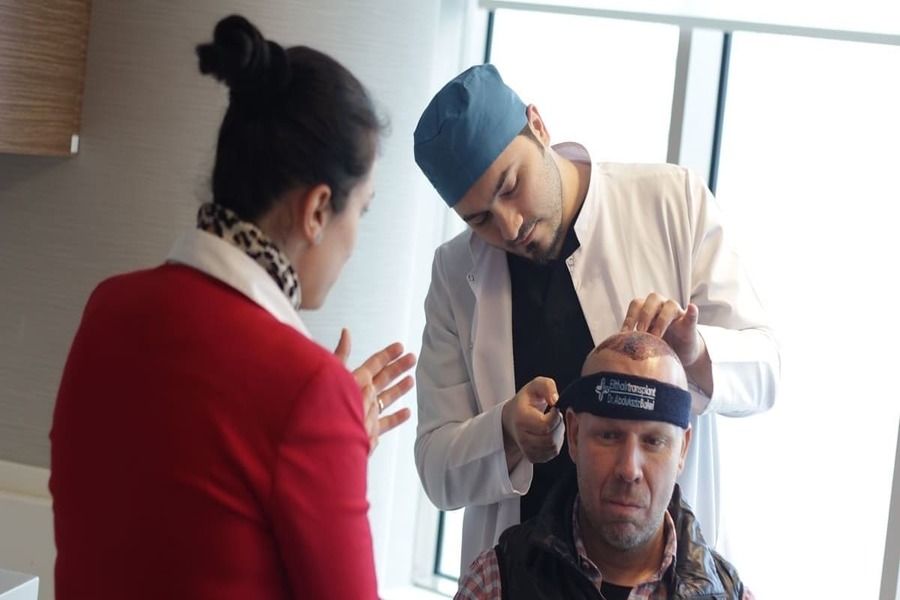 il dr Balwi controlla i tempi di recupero di un paziente dopo il trapianto di capelli