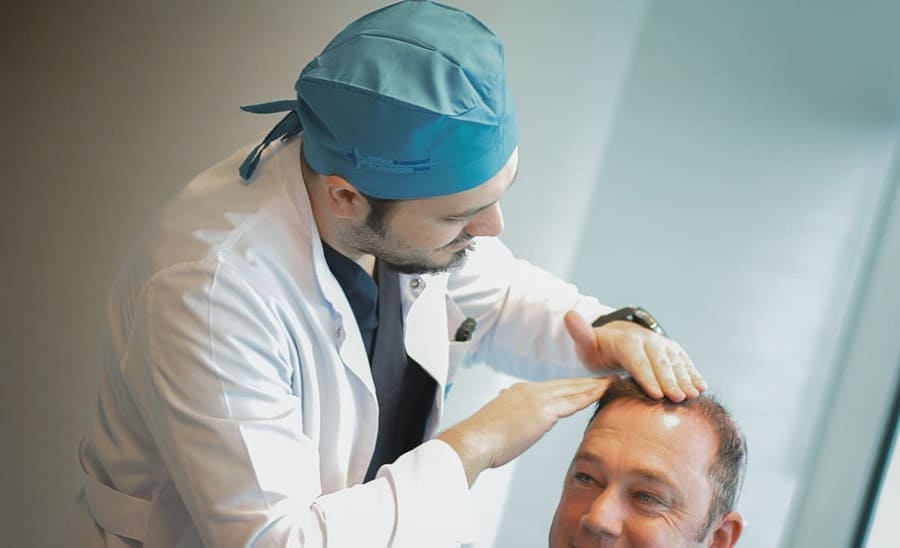 il dr balwi controlla la testa di un paziente che soffre di prurito post trapianto di capelli