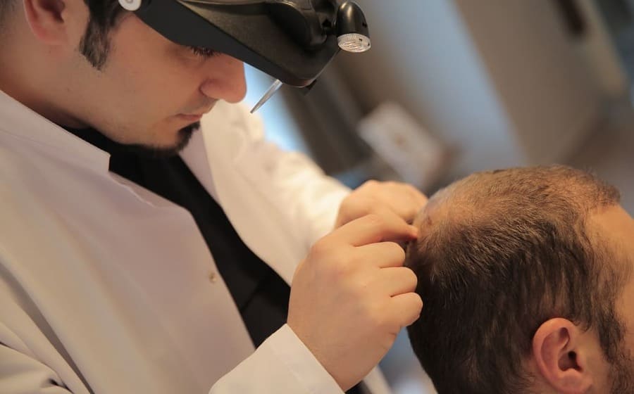 il Dr. Balwi controlla i brufoli dopo un trapianto di capelli di un paziente Elithair