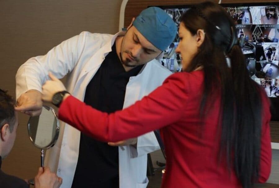 il Dr balwi mentre esamina un paziente per il secondo trapianto di capelli