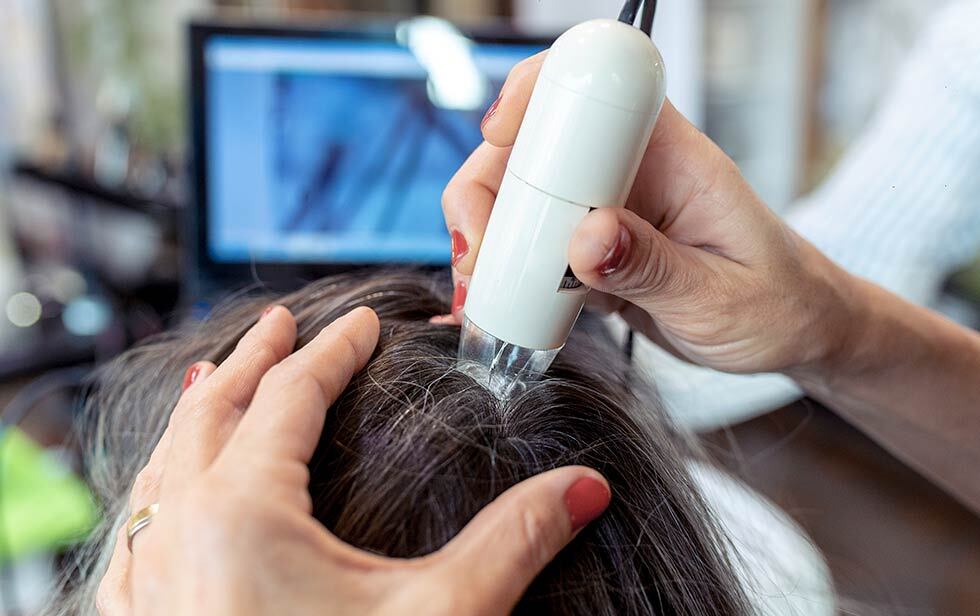 Especialista realiza exame de ultra-som no couro cabeludo de um paciente a Elithair