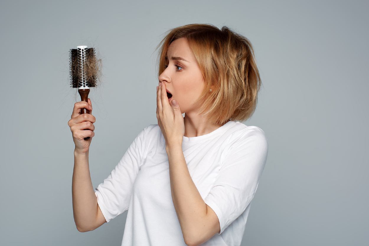 Mujer observando el cabello en su cepillo
