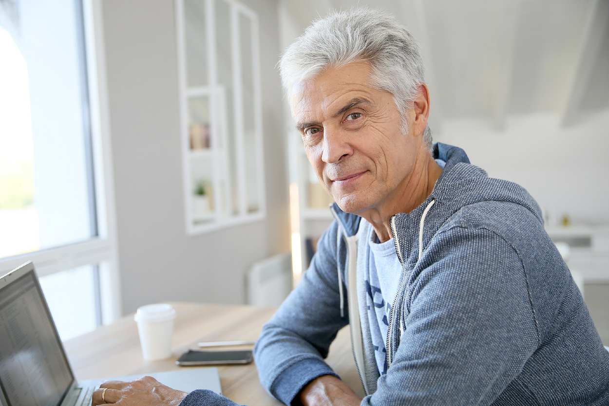 Hombre de 60 años con cabello blanco mirando a cámara