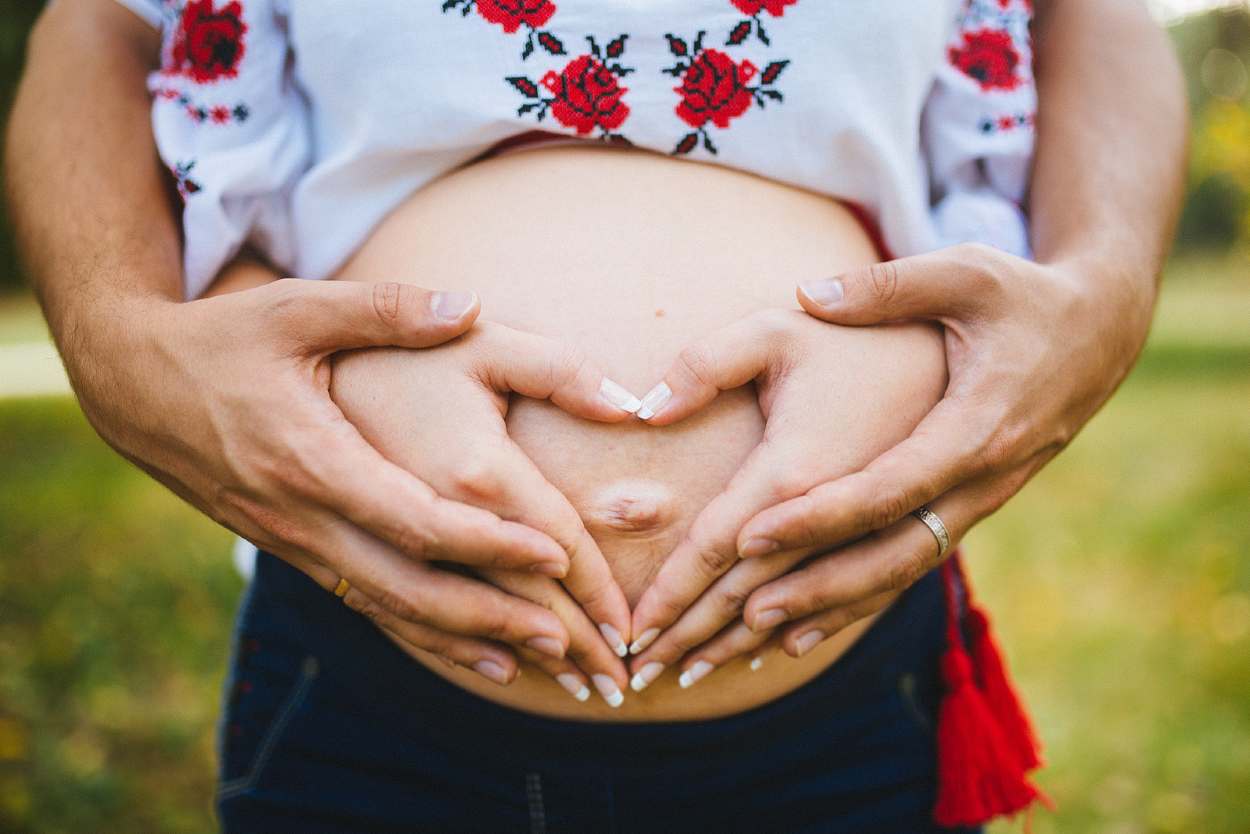 Mujer embarazada con su pareja sosteniendo el vientre