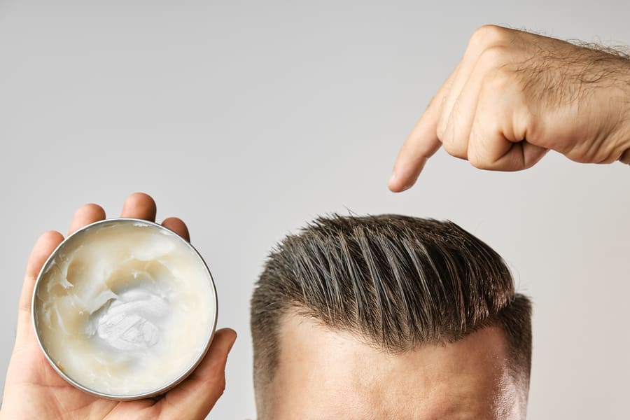 Hombre aplicando gomina para el pelo en la cabeza tras injerto capilar.