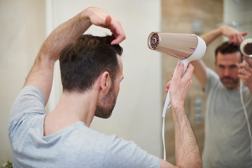 Hombre secándose el pelo con un secador
