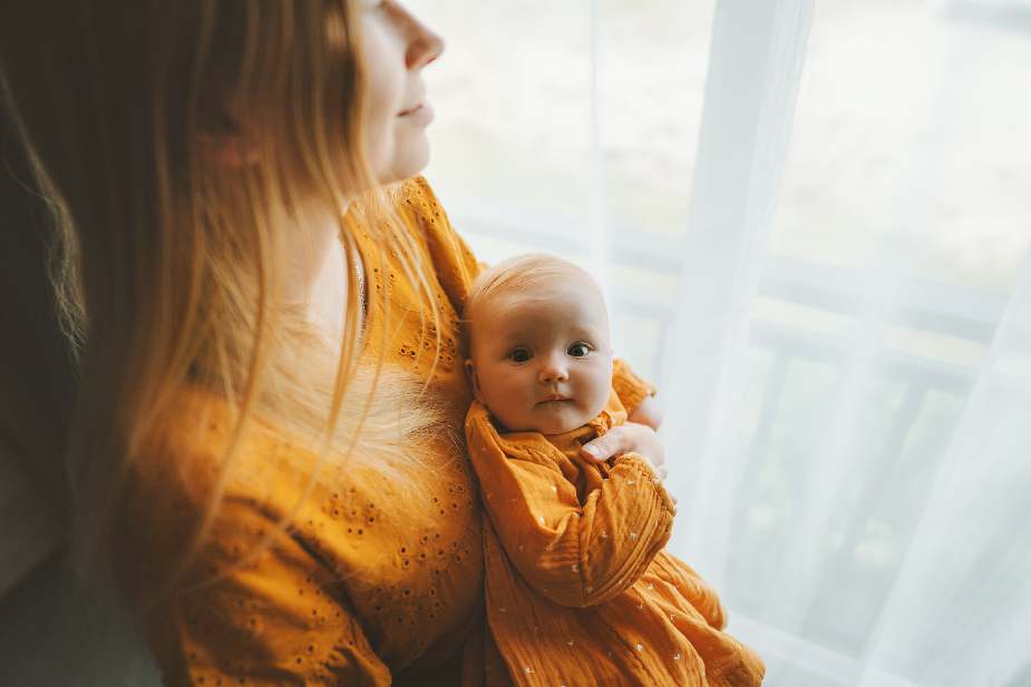 Mujer con cabello fino durante el postparto, sosteniendo a su bebé