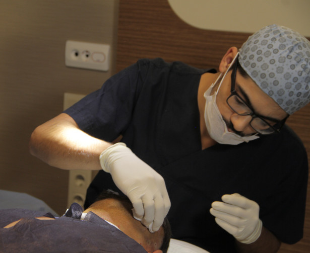 A hair transplant surgeon applying the local anaesthetic