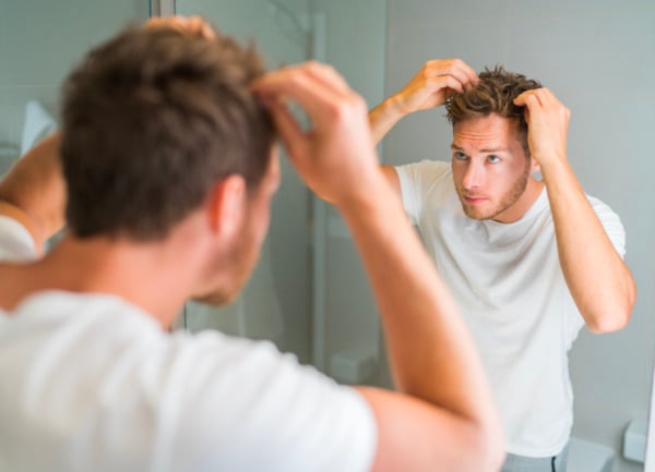a man looking at his thick hair after a hair transplant